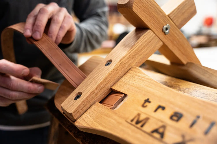 closeup of someone installing a leather strap onto a TrailMax wooden sawbuck tree