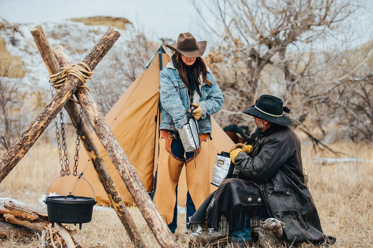 man and woman in front of small tent taking food out of saddlebag inserts