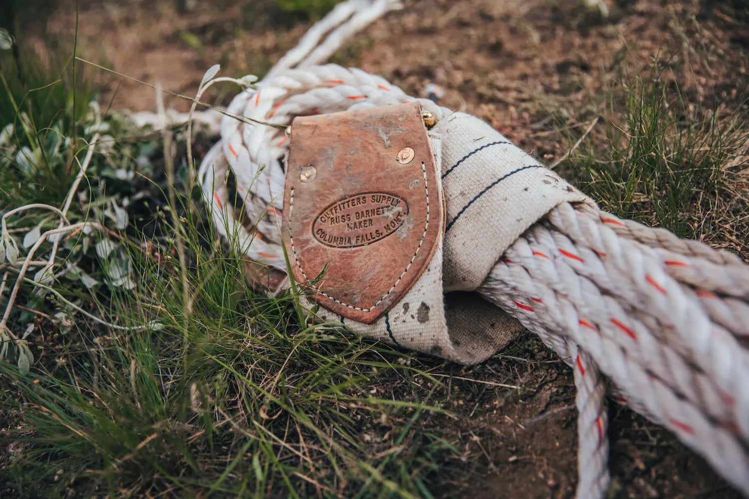 Closeup of lash rope tied to lash cinch, lying in the grass