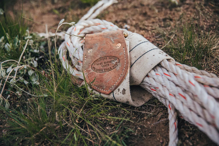 Closeup of lash rope tied to lash cinch, lying in the grass