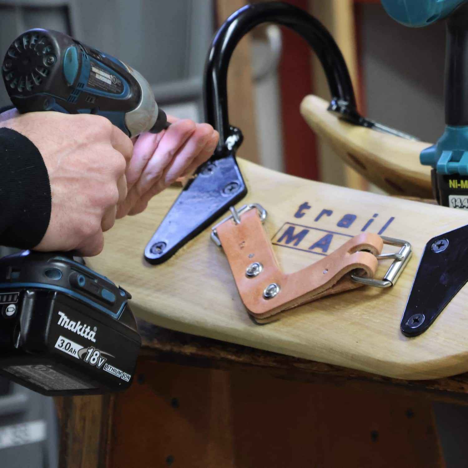 Closeup of person's hands holding a drill, assembling a TrailMax Cottonwood Decker Pack Saddle Tree.